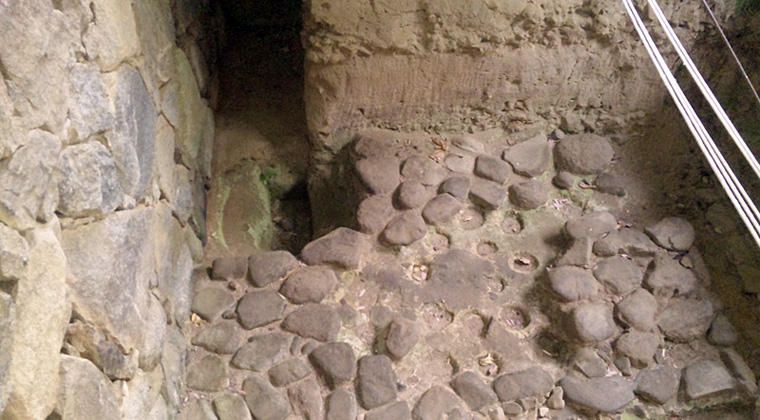 豊浦宮掘立柱抜き跡（左奥）と石敷（向原寺境内）